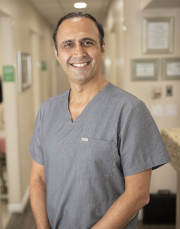 Dr. Penhaskashi standing in a gray scrub top smiling