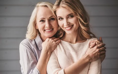 mother and daughter smiling after dental implant